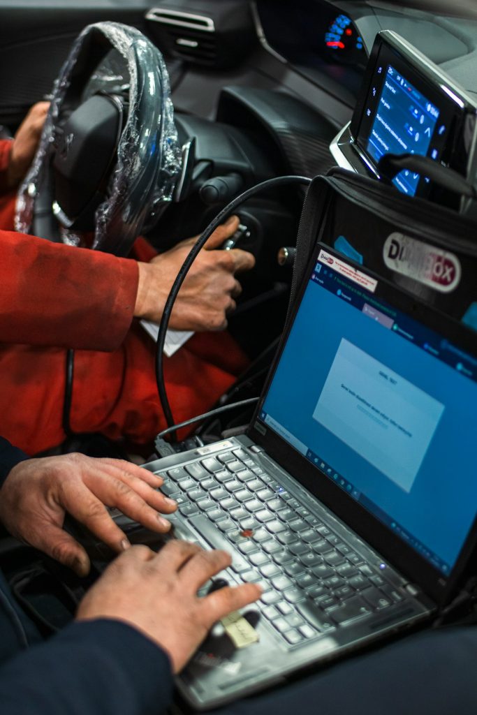 a-man-sitting-in-a-car-using-a-laptop-computer-seu9can7qla